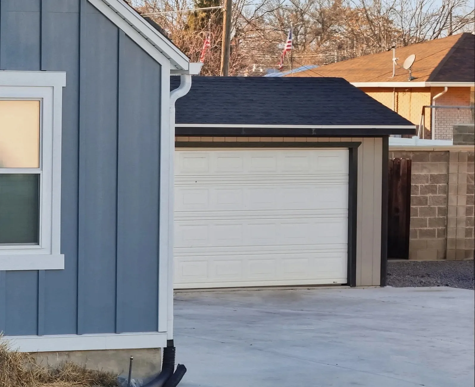 White sectional garage door on a detached garage with a concrete driveway